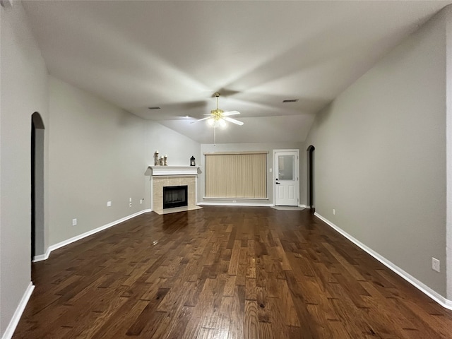 unfurnished living room with a tile fireplace, ceiling fan, dark hardwood / wood-style flooring, and vaulted ceiling