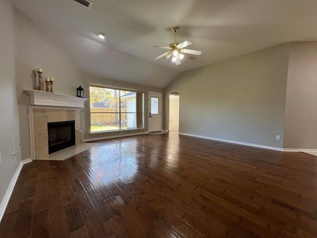 unfurnished living room with a tile fireplace, ceiling fan, dark hardwood / wood-style flooring, and vaulted ceiling