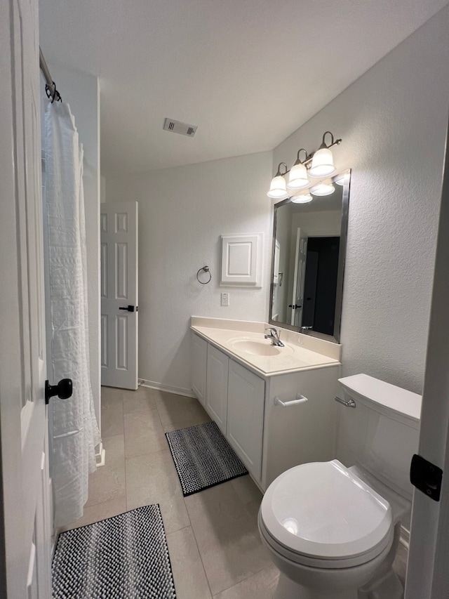 bathroom with tile patterned flooring, vanity, and toilet