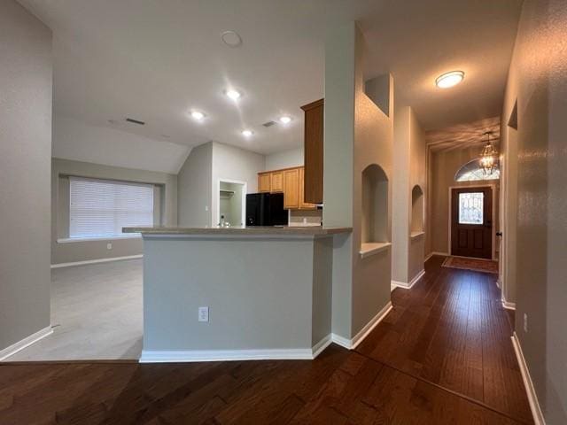 kitchen featuring dark hardwood / wood-style floors, kitchen peninsula, a chandelier, and fridge