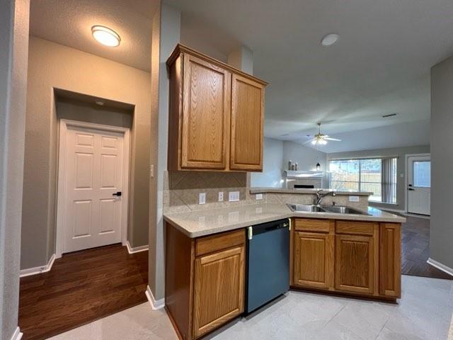 kitchen with dishwasher, kitchen peninsula, and sink