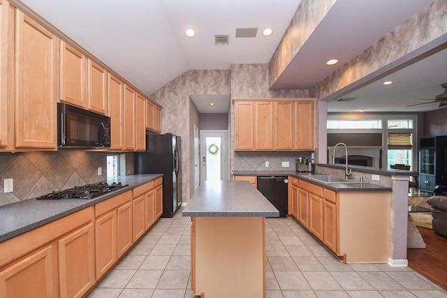 kitchen featuring light brown cabinetry, sink, black appliances, a kitchen island, and lofted ceiling