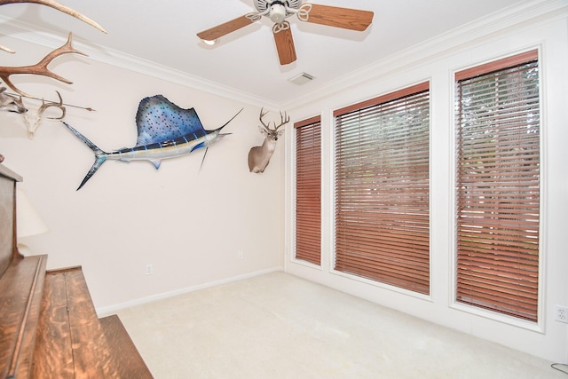 spare room with light colored carpet, ceiling fan, and crown molding