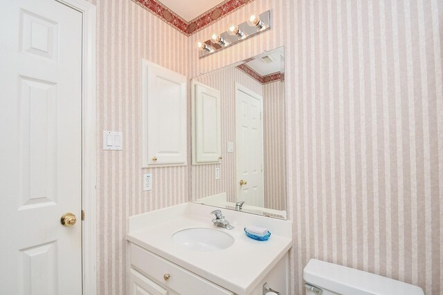 2446 Plantation Bend Dr, Sugar Land, TX 77478 - half bathroom featuring wallpapered walls, toilet, and vanity