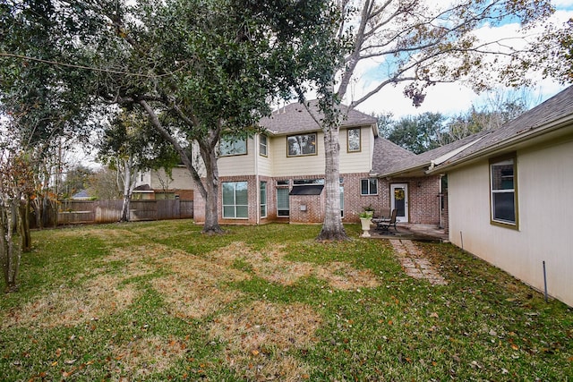 back of property with a yard and a patio