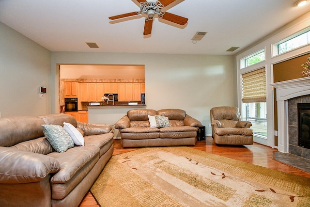 2446 Plantation Bend Dr, Sugar Land, TX 77478 - living room featuring light wood finished floors, a fireplace, and a ceiling fan