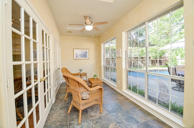 sunroom featuring ceiling fan and french doors