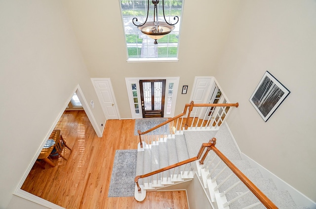 foyer featuring a chandelier, hardwood / wood-style floors, and a towering ceiling