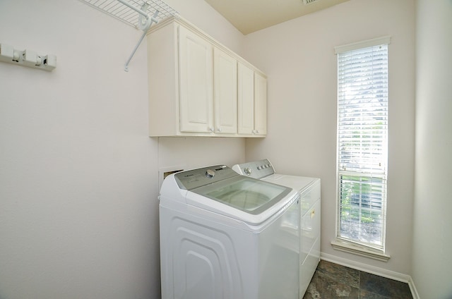 clothes washing area featuring cabinets and washing machine and dryer