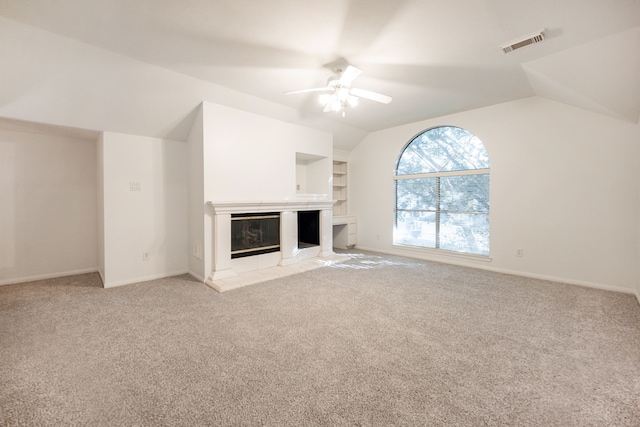 unfurnished living room featuring ceiling fan, light colored carpet, lofted ceiling, and a tile fireplace