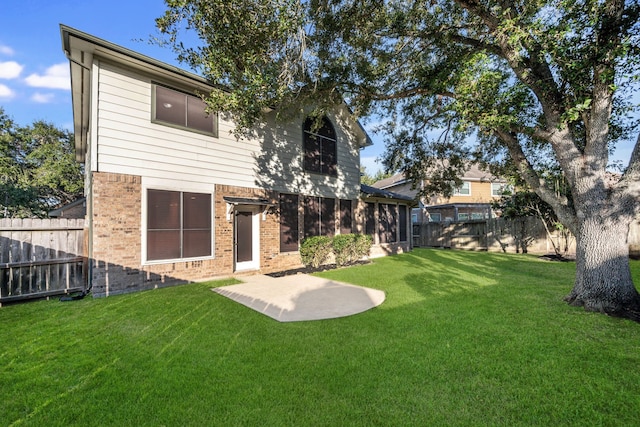 back of property with a lawn and a patio