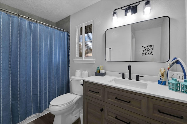 bathroom with vanity, a textured ceiling, and toilet