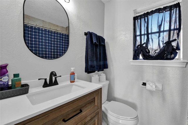 bathroom with vanity, a shower with shower curtain, and toilet