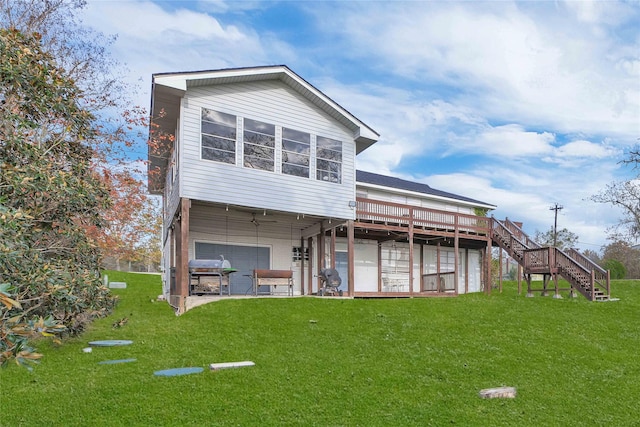 rear view of house featuring a jacuzzi, a yard, and a deck