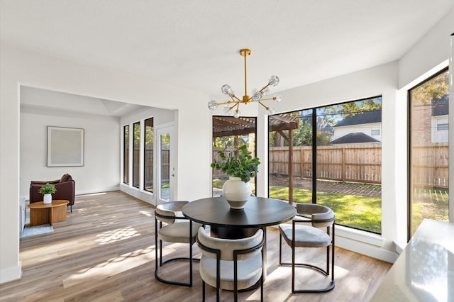 sunroom / solarium featuring a notable chandelier