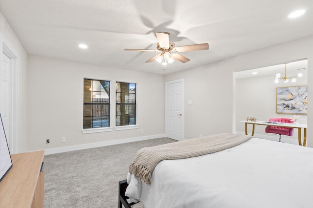 carpeted bedroom with ceiling fan with notable chandelier