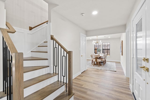 foyer with an inviting chandelier and light hardwood / wood-style flooring