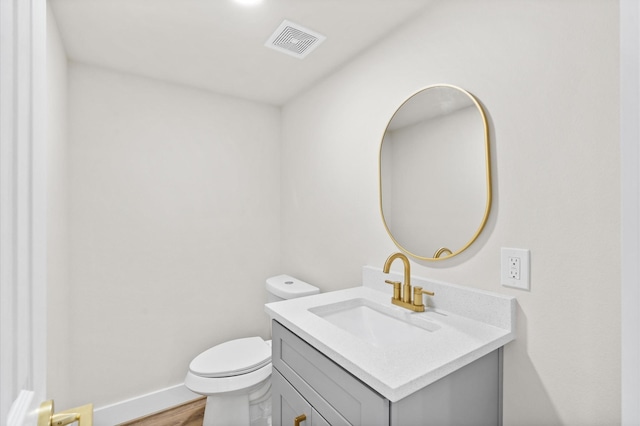 bathroom with vanity, toilet, and wood-type flooring