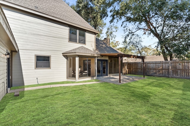 rear view of house featuring a lawn, a patio area, and french doors