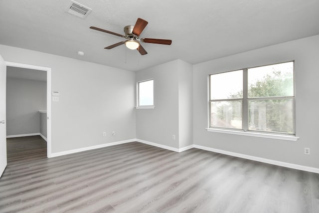 unfurnished room with ceiling fan, a textured ceiling, and hardwood / wood-style flooring