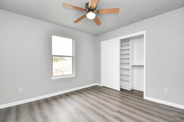 unfurnished bedroom with a closet, dark hardwood / wood-style floors, and ceiling fan