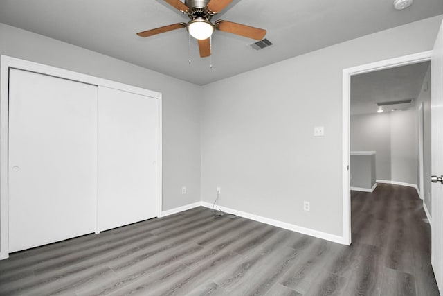 unfurnished bedroom featuring a closet, ceiling fan, and dark wood-type flooring