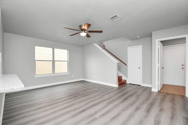 unfurnished living room featuring a textured ceiling, light hardwood / wood-style floors, and ceiling fan