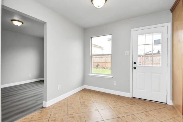 foyer featuring light tile patterned floors and a healthy amount of sunlight