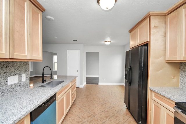 kitchen with decorative backsplash, appliances with stainless steel finishes, light stone counters, sink, and light brown cabinets