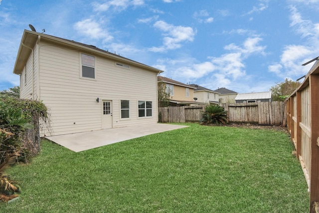 back of house with a yard and a patio