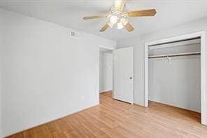 unfurnished bedroom featuring a closet, light hardwood / wood-style flooring, and ceiling fan