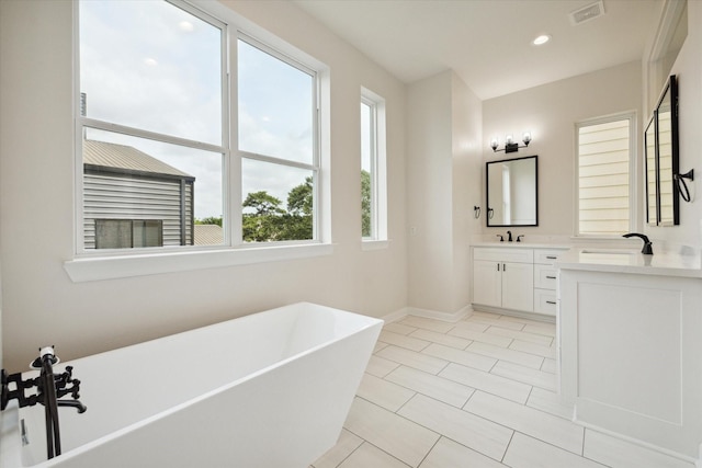 bathroom with vanity, tile patterned floors, and a tub