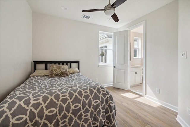 bedroom featuring ceiling fan, light hardwood / wood-style floors, and connected bathroom