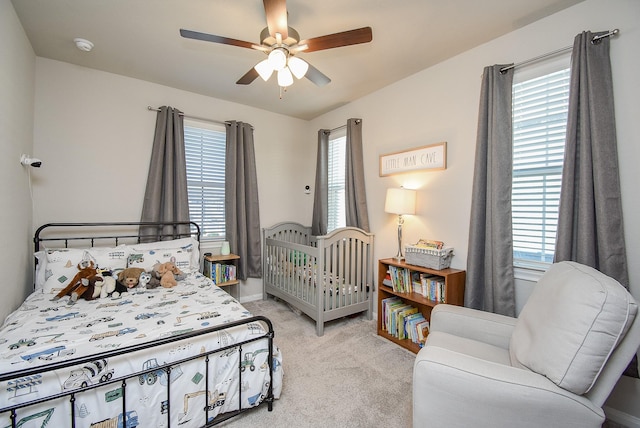 carpeted bedroom featuring ceiling fan and multiple windows