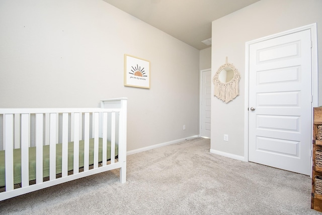 unfurnished bedroom with light colored carpet and a crib