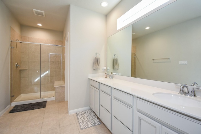 bathroom with tile patterned flooring, vanity, and walk in shower