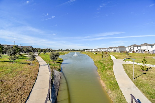 view of home's community with a lawn and a water view