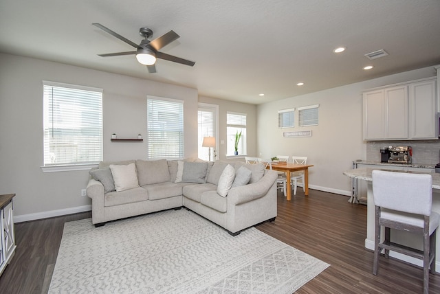 living room featuring ceiling fan and dark wood-type flooring