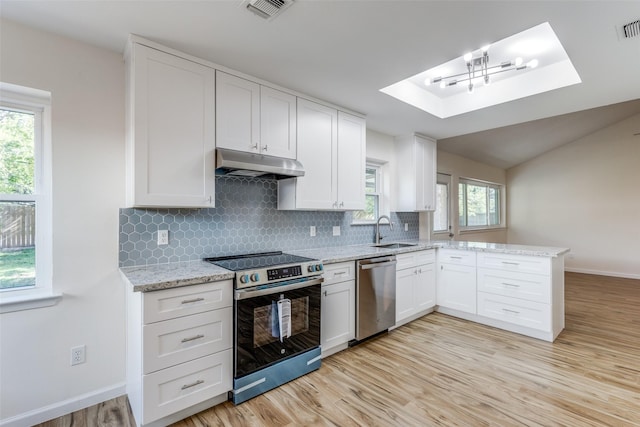 kitchen with plenty of natural light, white cabinets, stainless steel appliances, and sink