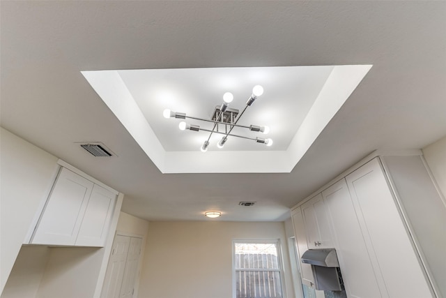 details with a chandelier and a tray ceiling