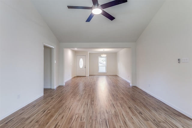 unfurnished living room with ceiling fan, light wood-type flooring, and lofted ceiling