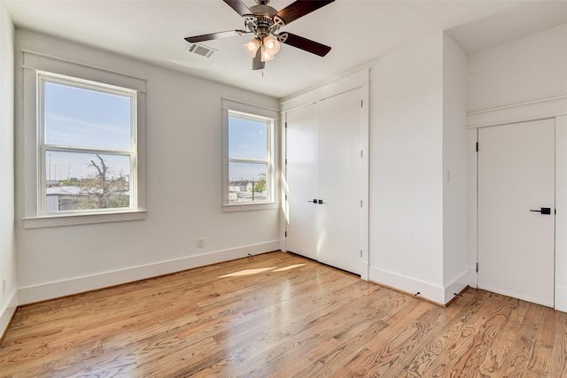 unfurnished bedroom with multiple windows, ceiling fan, and light wood-type flooring