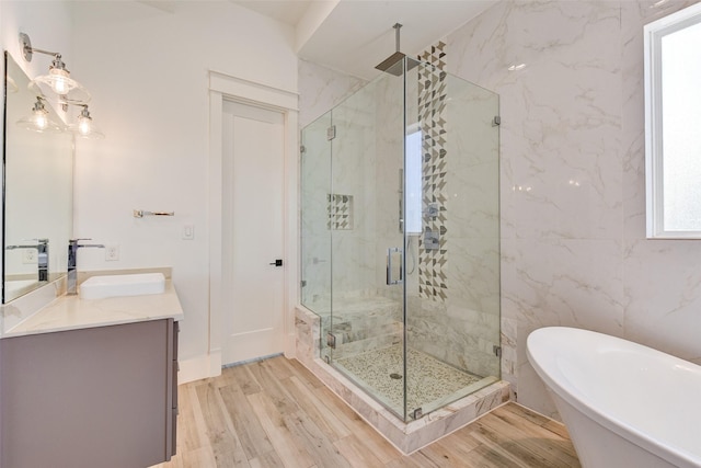 bathroom featuring hardwood / wood-style flooring, vanity, and separate shower and tub