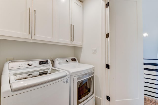 laundry room featuring cabinets and washer and clothes dryer