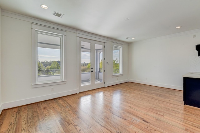 unfurnished living room featuring crown molding, french doors, and light hardwood / wood-style flooring