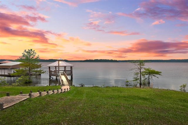 view of dock featuring a water view and a lawn