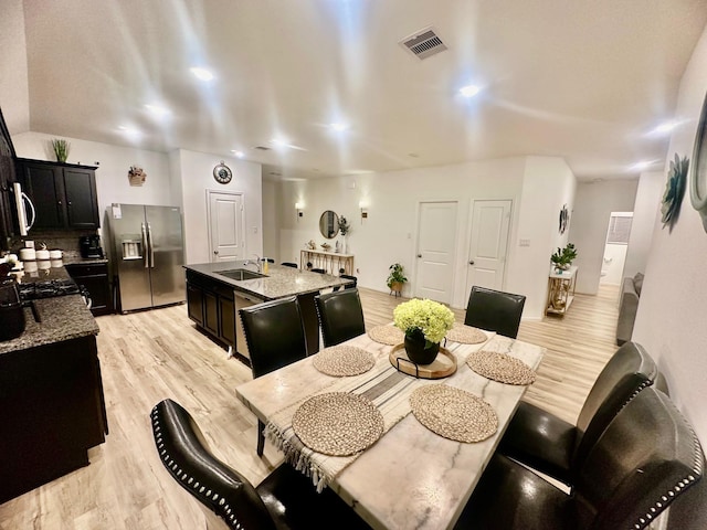 dining room with light hardwood / wood-style floors and sink