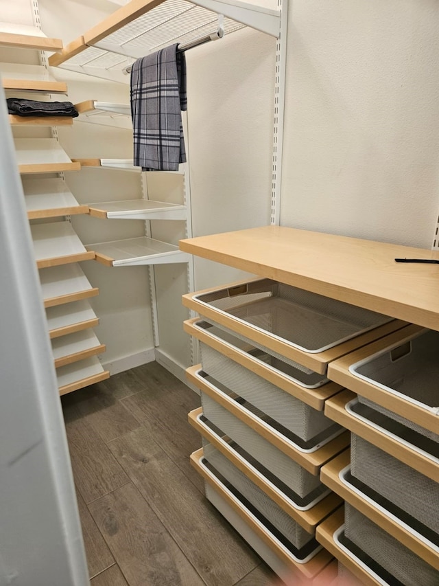 walk in closet with dark wood-type flooring