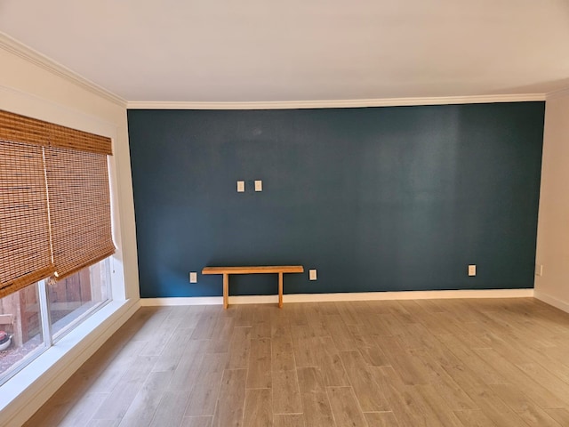 spare room with ornamental molding and light hardwood / wood-style flooring