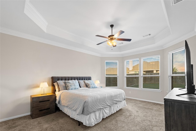 carpeted bedroom with ceiling fan, ornamental molding, and a tray ceiling